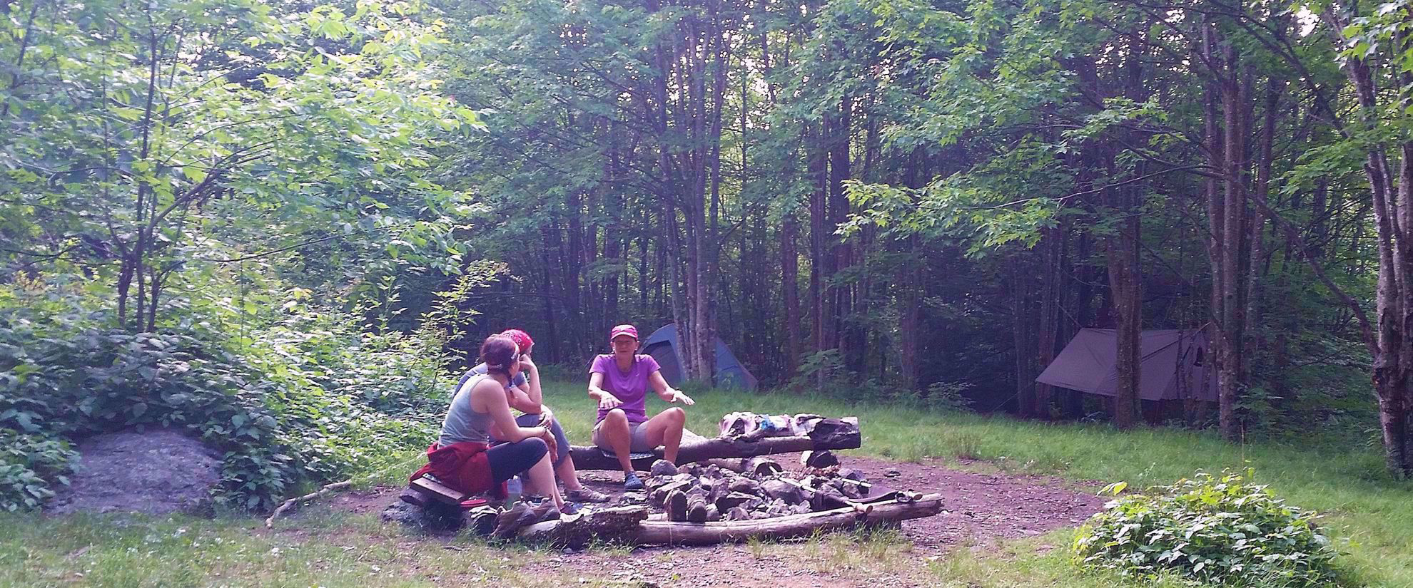 Female travel group chatting by campsite on Appalachian Trail
