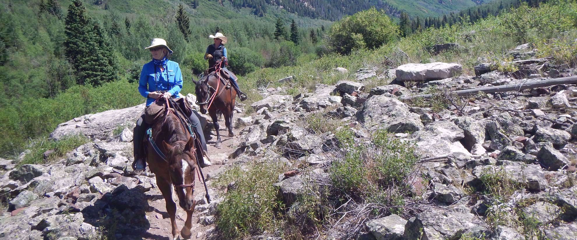 women's travel group horseback riding through rockies