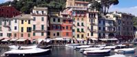 Docked boats along Italian riviera with colorful buildings in background
