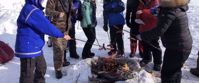 roasting hot dogs over open flame in winter