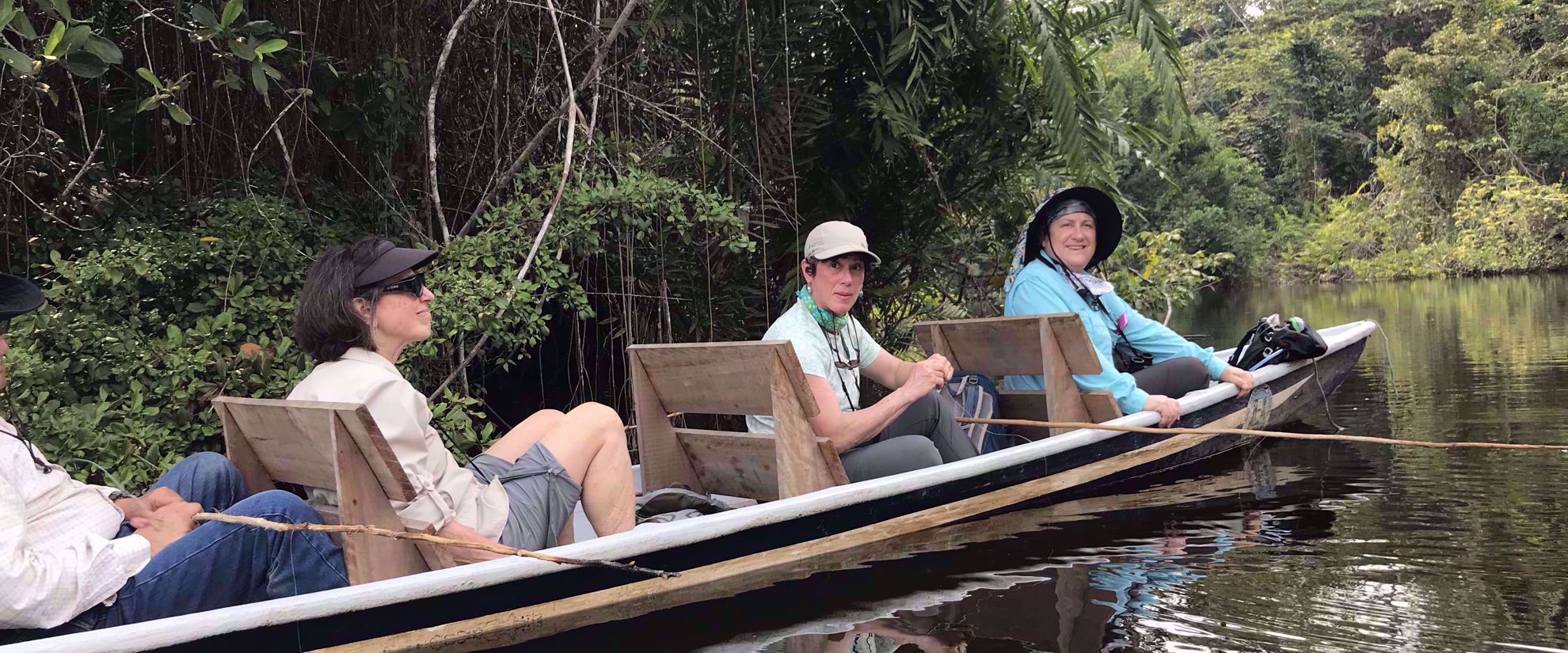 women smiling from canoe ecuador travel tour