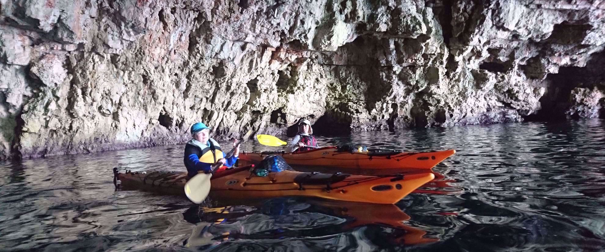women's travel group kayaking through caves in croatia