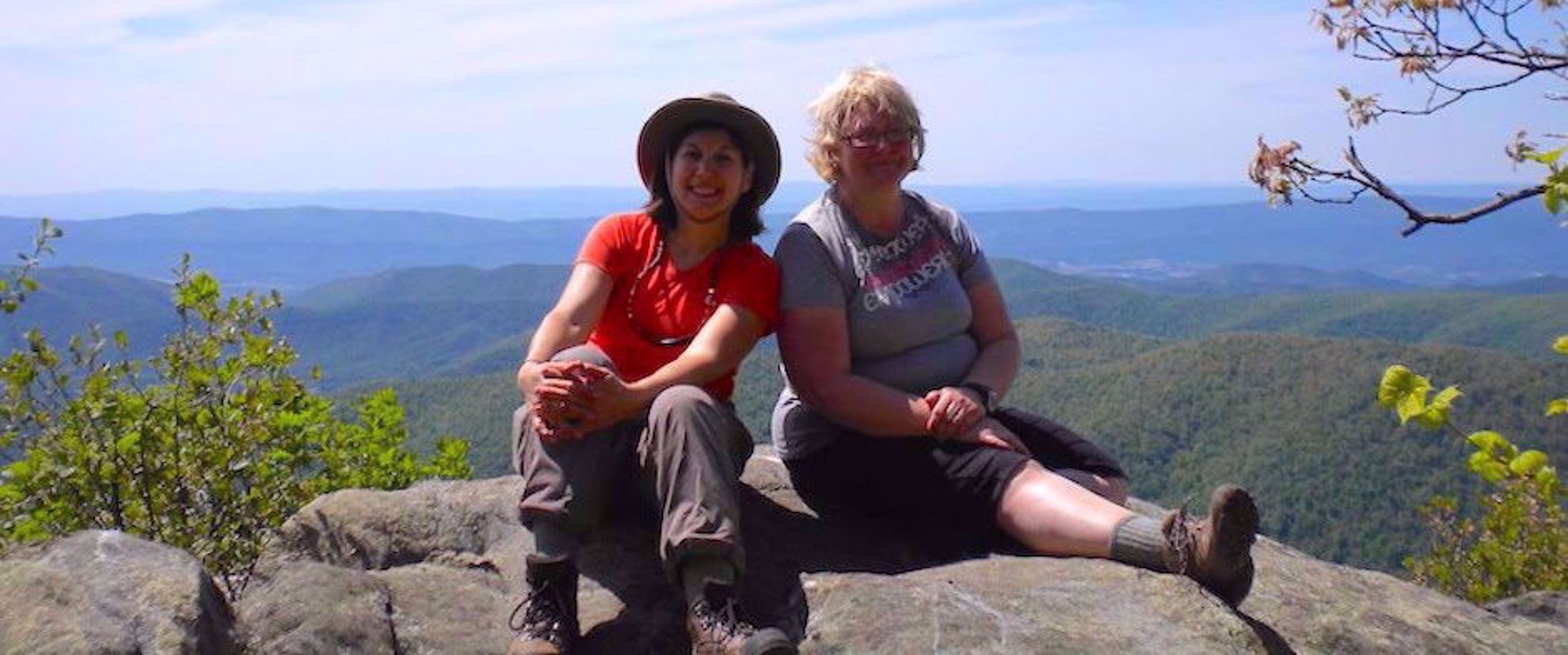two women sitting smiling on rock appalachian trail