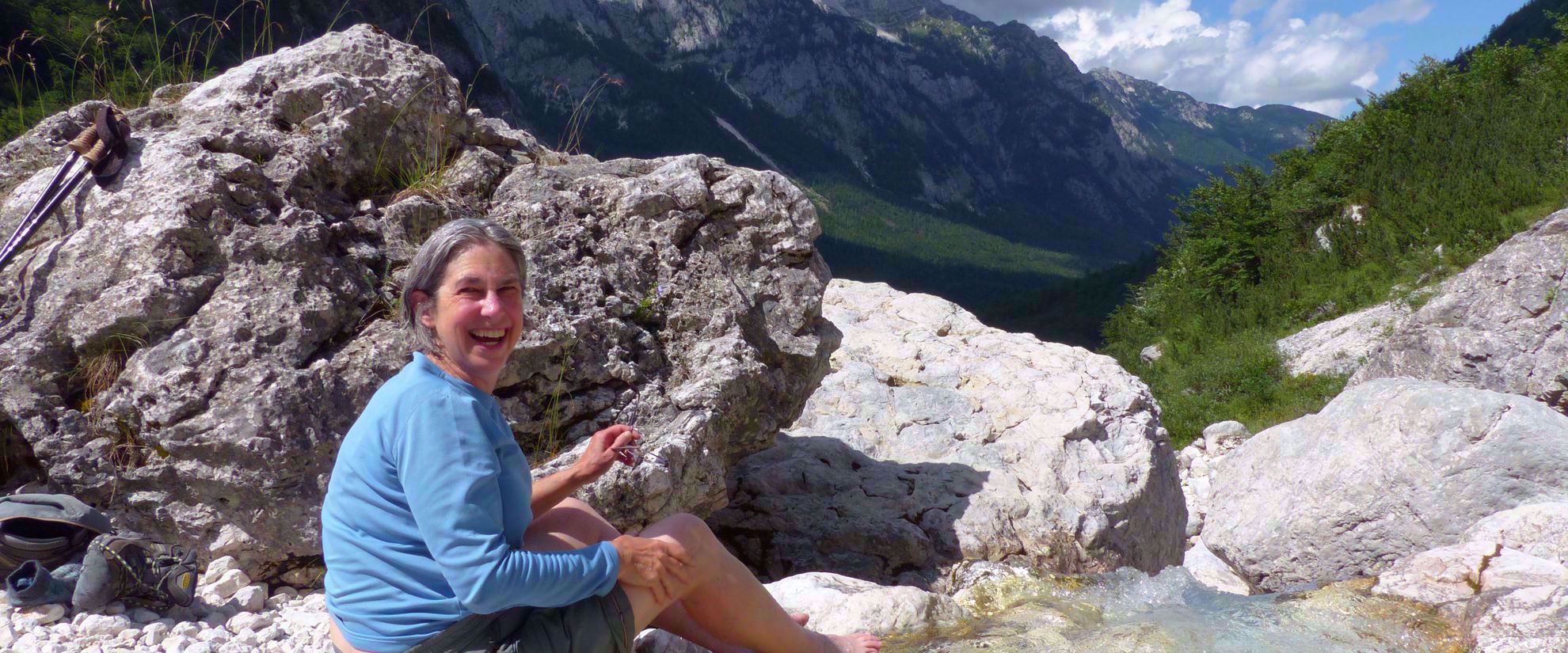 Picture of Hiking Slovenia and the Julian Alps woman laughs dips feet in cold water slovenia