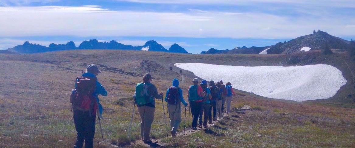 women hiking through snowy mountains olympic national park