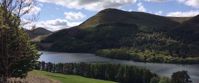 Picture of Tramping the Lake District Grassy treed mountain with lake on cloudy day