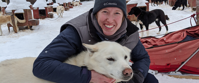 Smiling pax with a happy sled dog
