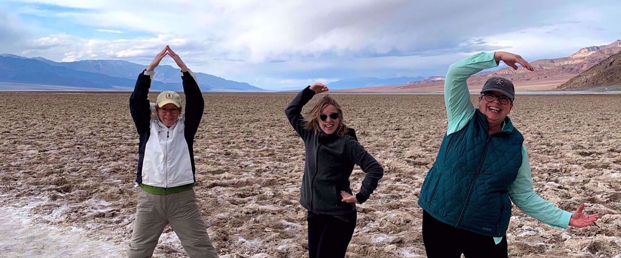 women spelling out AGC with their arms in death valley