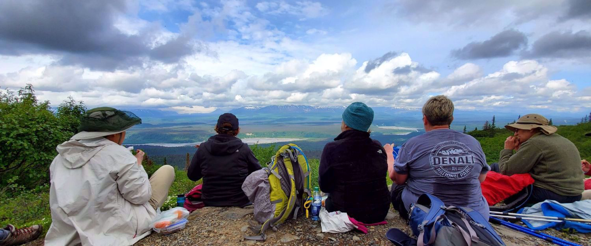participants sitting on mountain admiring Alaskan beauty