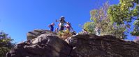 Picture of Appalachian Autumn Adventures Women hiking Appalachian trail, standing on rock looking down and smiling