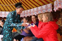 Woman handing a woman a bowl